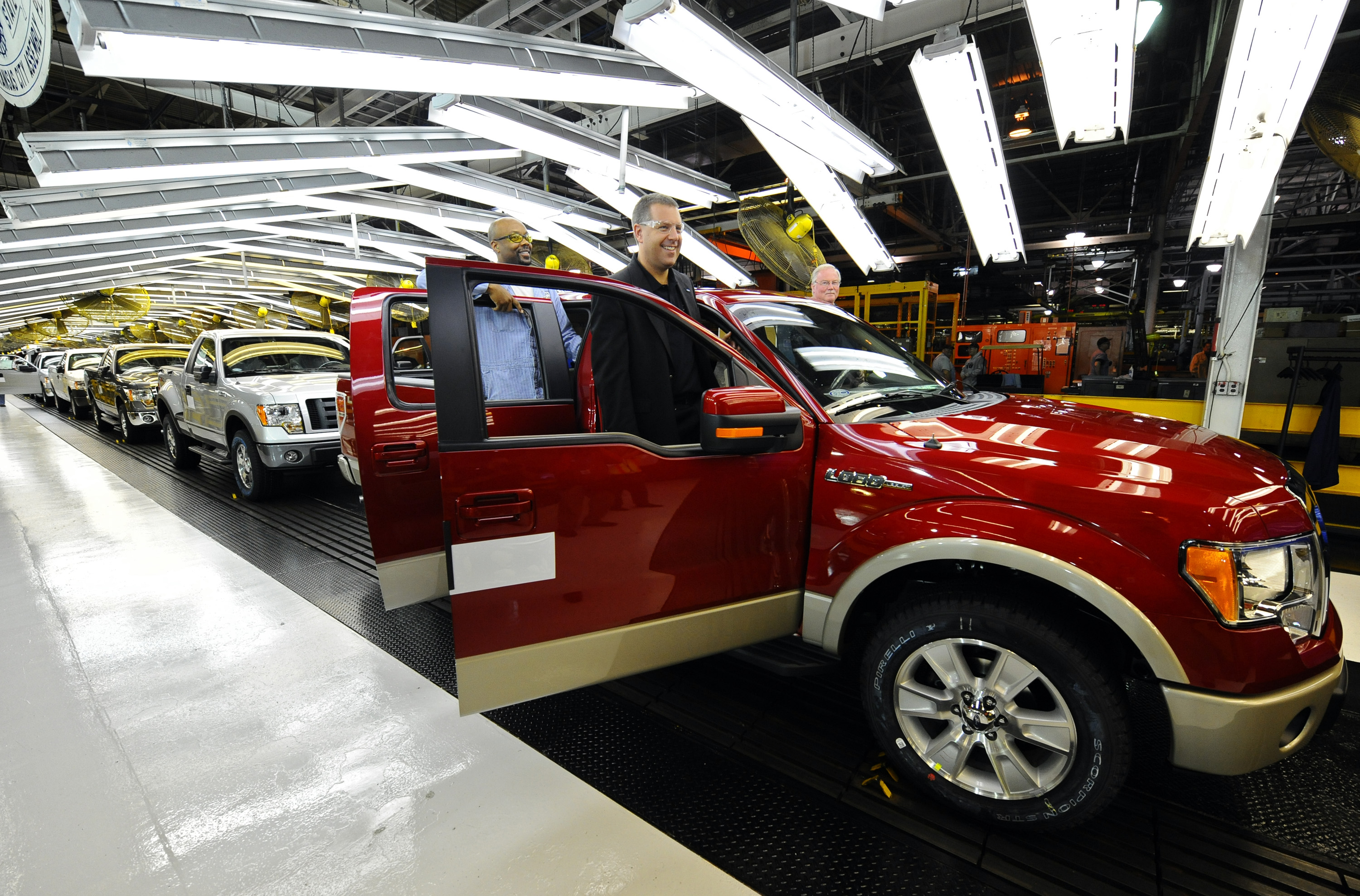 CLAYCOMO, MO - OCTOBER 2: Joe Hinrichs, VP of Global Mfg. and Labor Affairs (R) and Gregory Armstrong, a 17-year Ford employee, stand in the doors of a Ford F-150 Lobo pickup on the final assembly line at the Kansas City Ford Assembly plant October 2, 2008 in Claycomo, Missouri. Ford's Kansas City Assembly plant celebrates production of the new 2009 Ford F-150 with the official roll out. (Photo by Larry W. Smith/Getty Images)